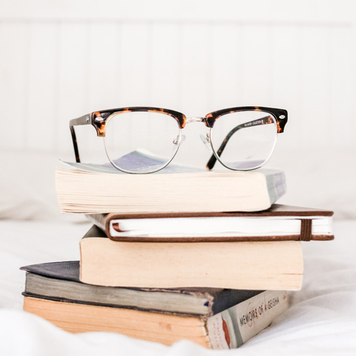 eye frames on pile of books